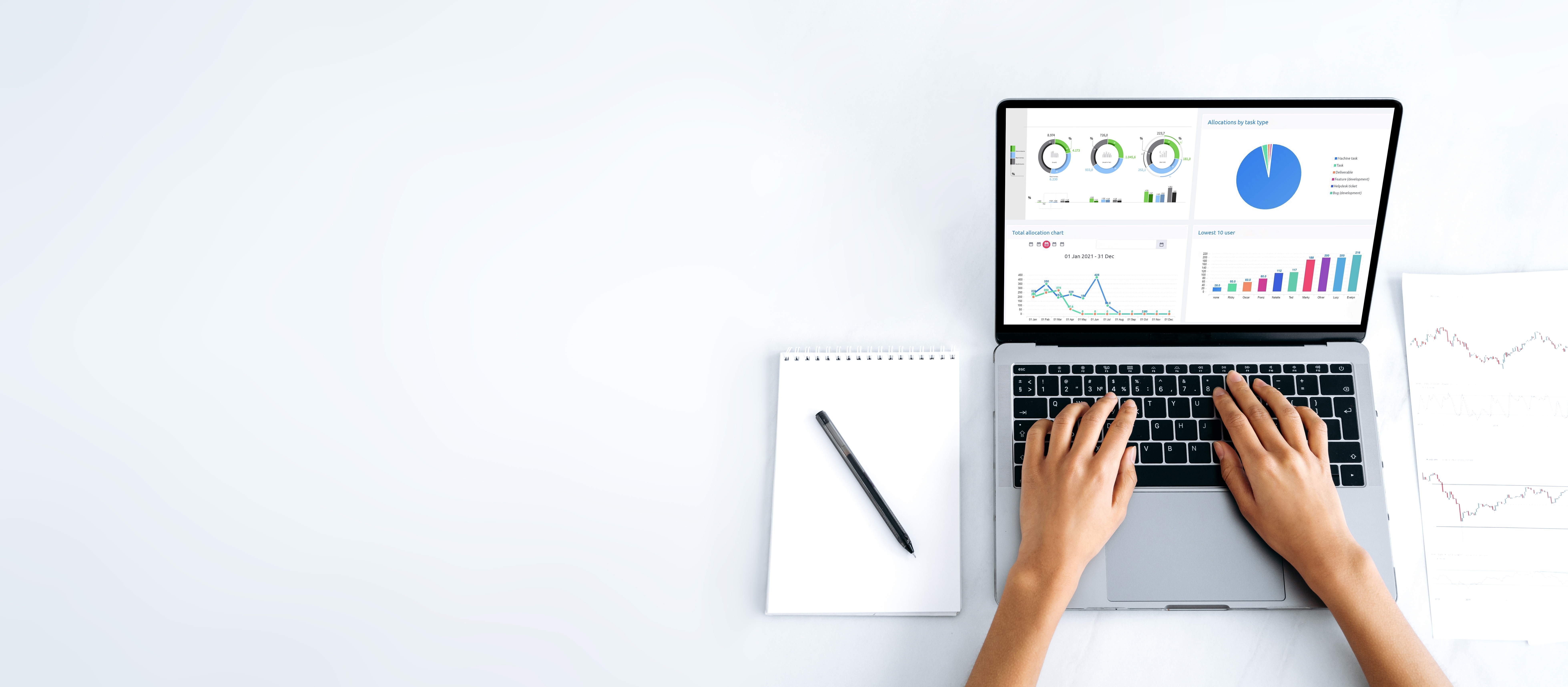 Image of hands on a laptop keyboard and charts on the screen